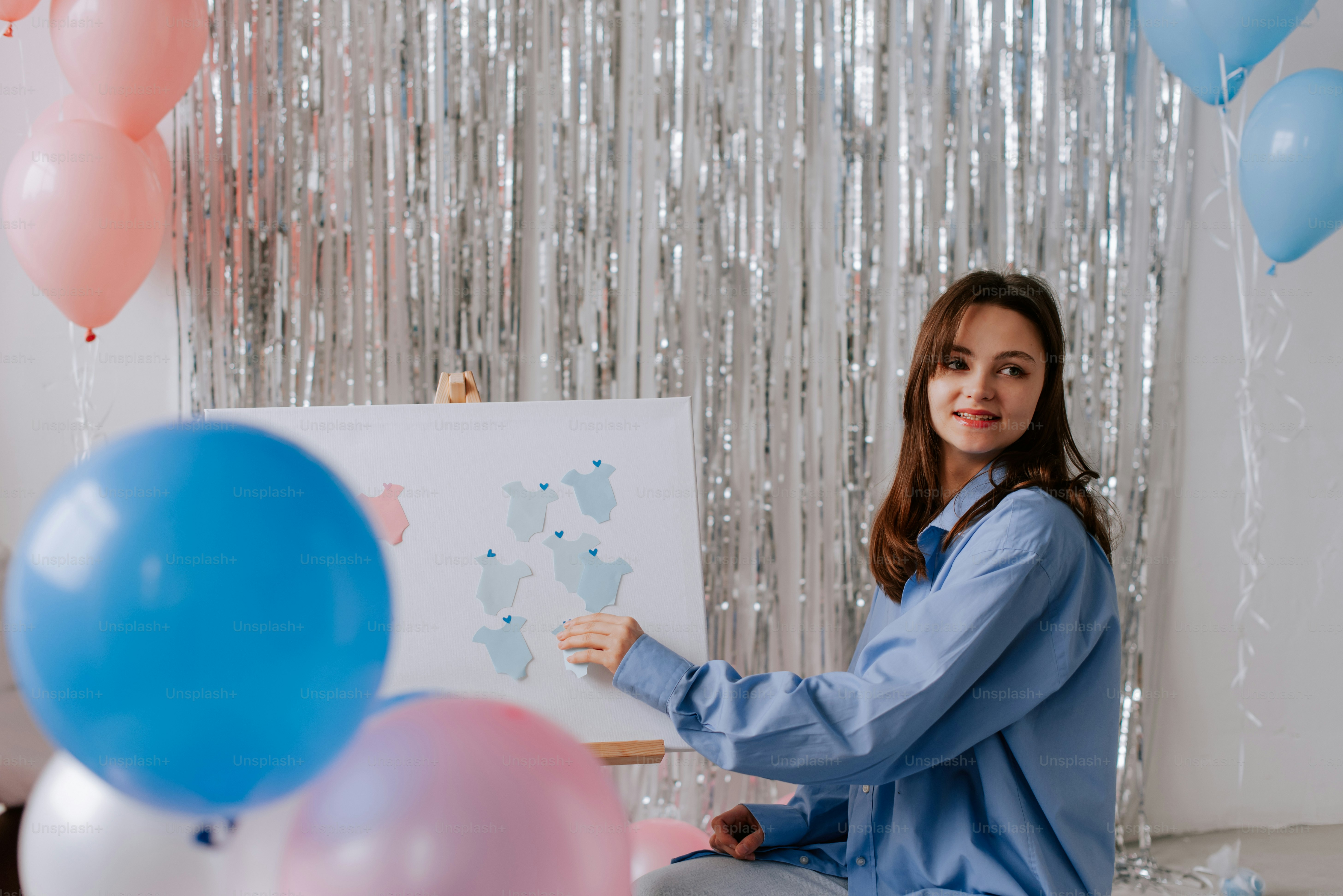 Una mujer sentada en una silla frente a globos - Foto en Unsplash+