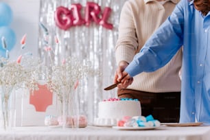 a man and woman cutting a cake together