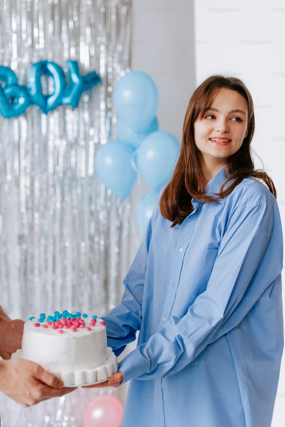 a woman standing next to a man holding a cake