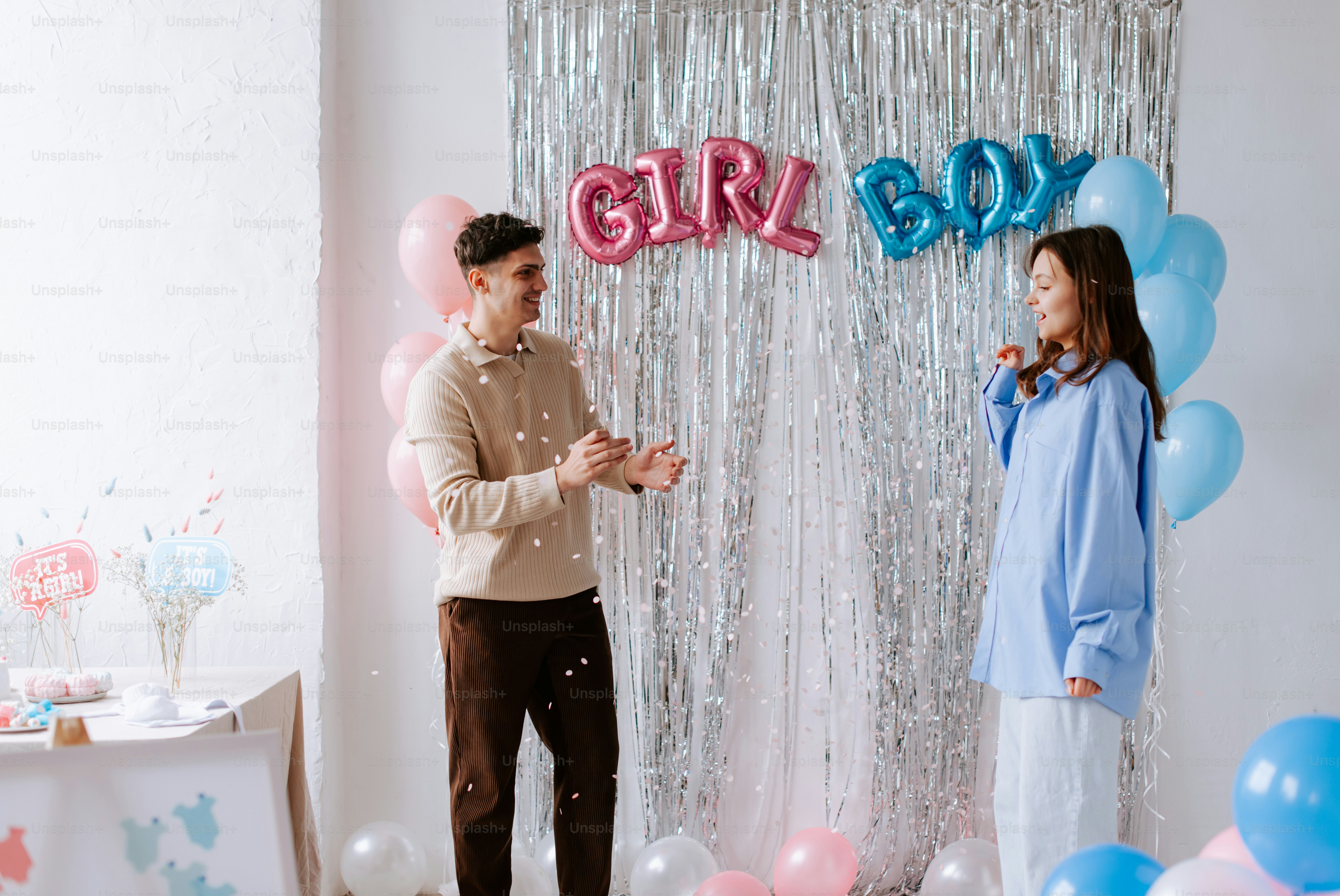 a man standing next to a woman in front of balloons