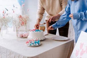 Ein Mann und eine Frau schneiden gemeinsam einen Kuchen an