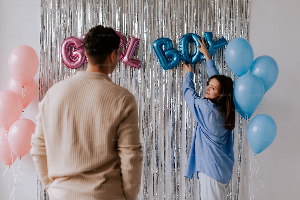 a man and a woman standing in front of balloons