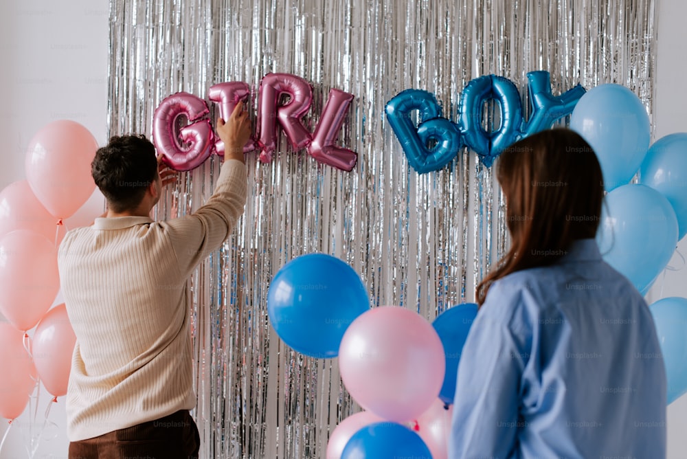 a man and a woman standing in front of balloons