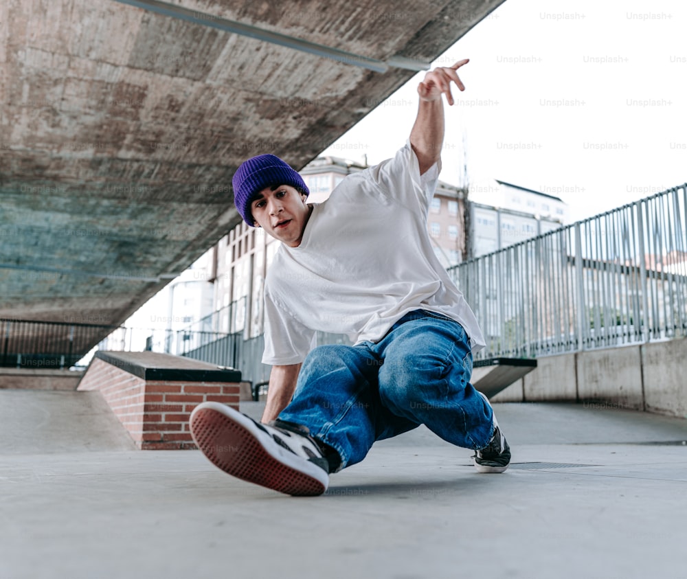 a young man riding a skateboard under a bridge