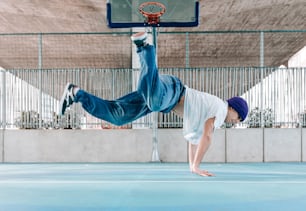un homme faisant le poirier sur un terrain de basket-ball