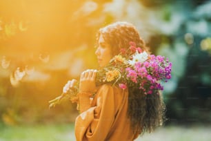 a woman holding a bunch of flowers in her hands