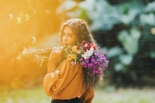 a woman holding a bunch of flowers in her hands