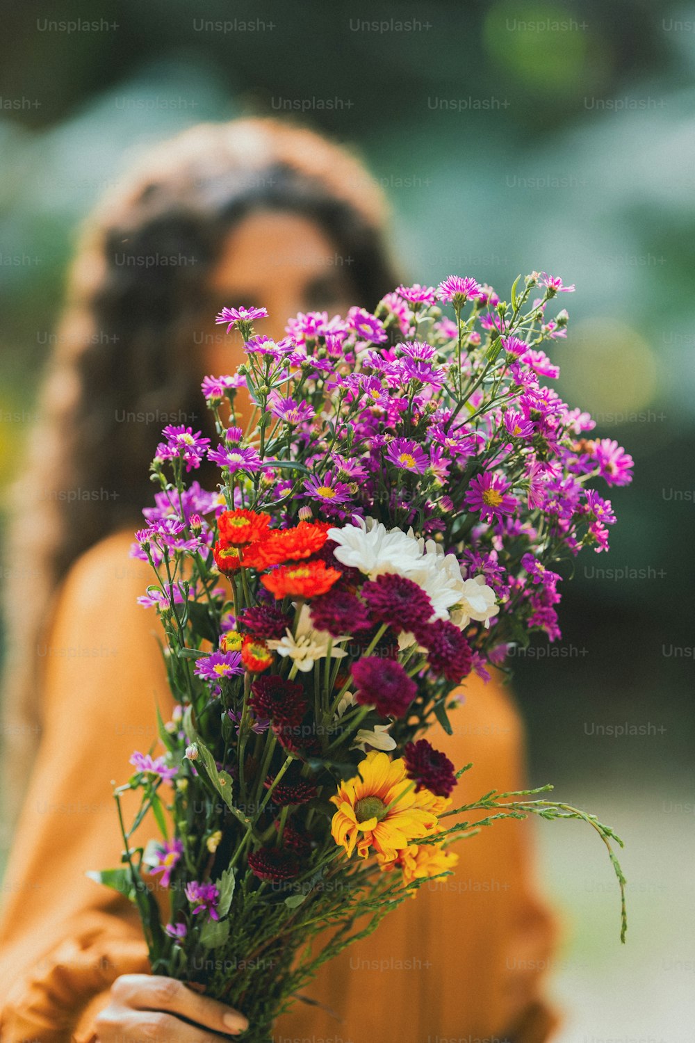 a woman holding a bouquet of flowers in her hands