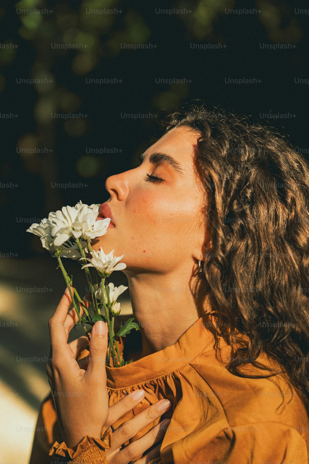 a woman smelling a bunch of white flowers