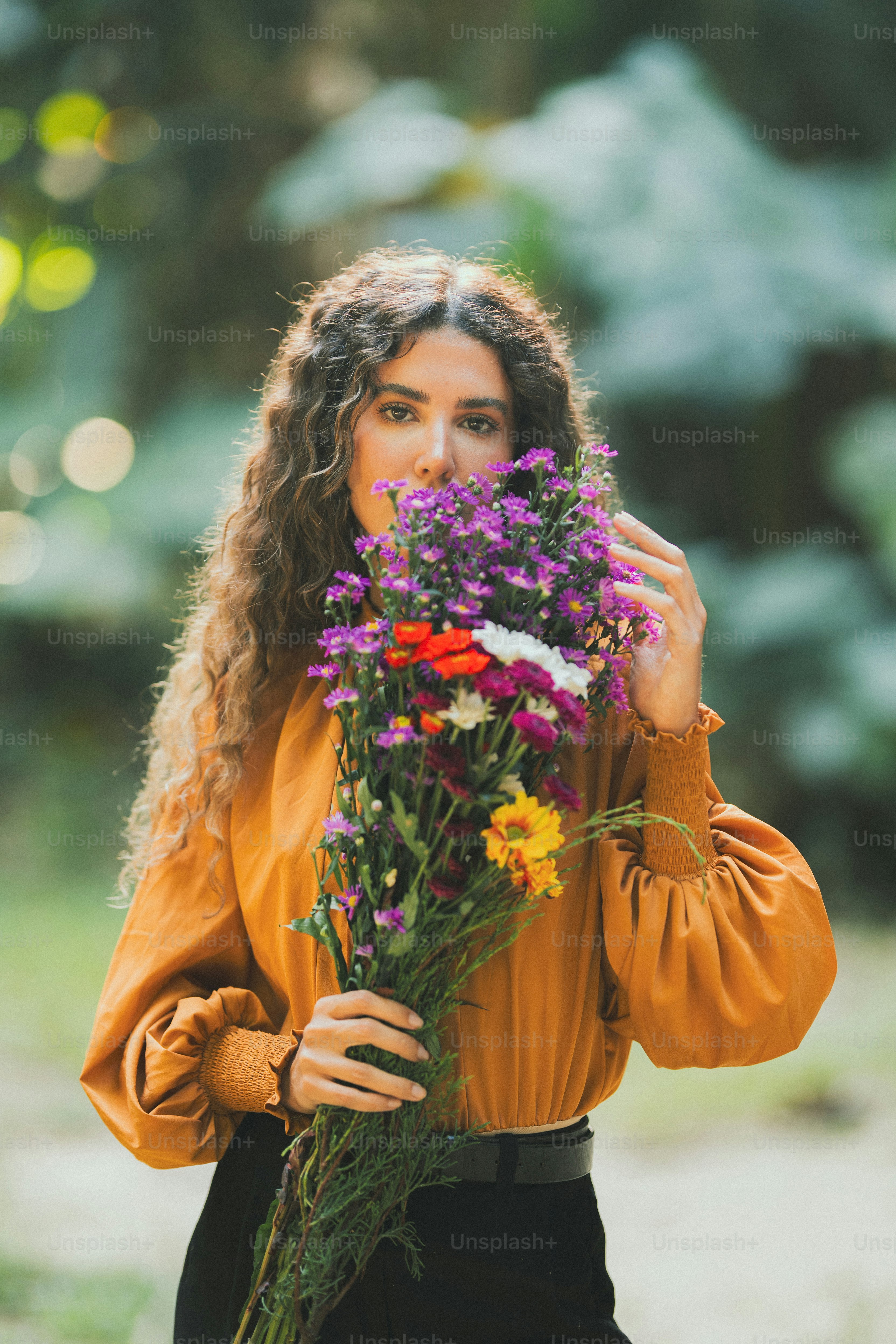 A woman holding a bunch of flowers in her hands photo – Flowers Image ...