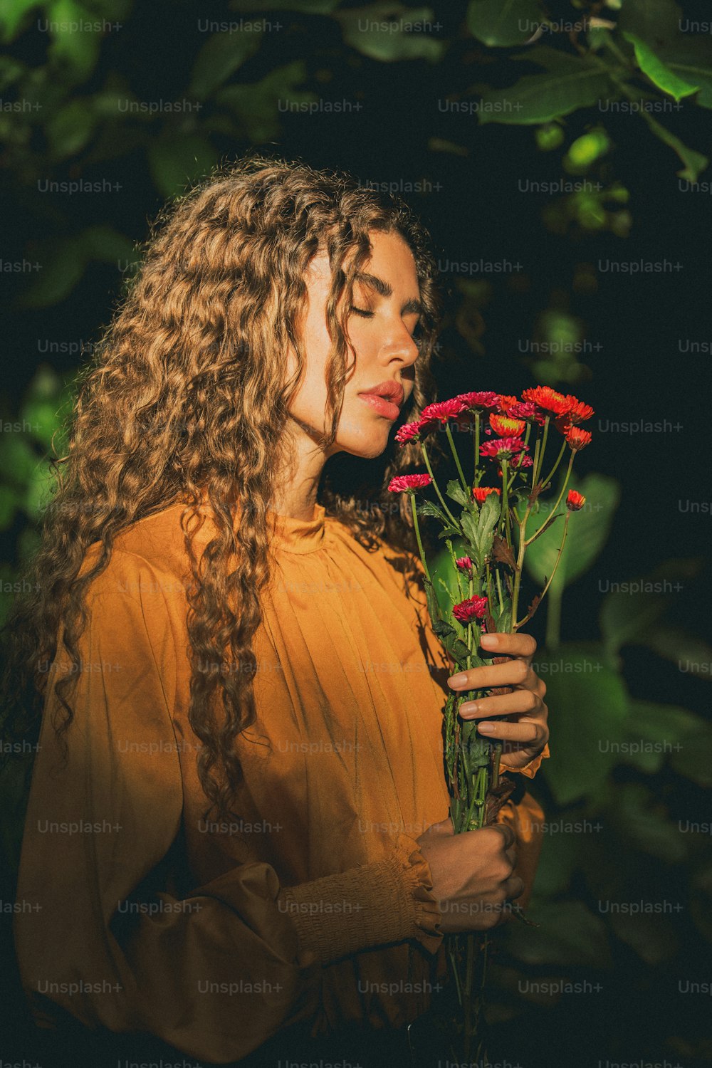 a woman holding a bunch of red flowers