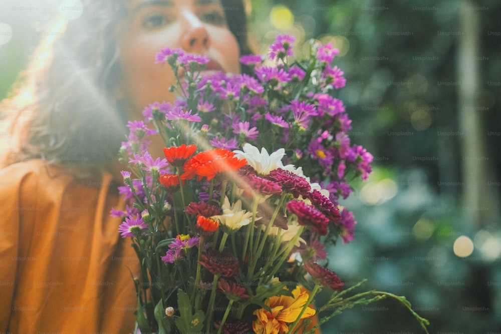 uma mulher segurando um ramo de flores em suas mãos