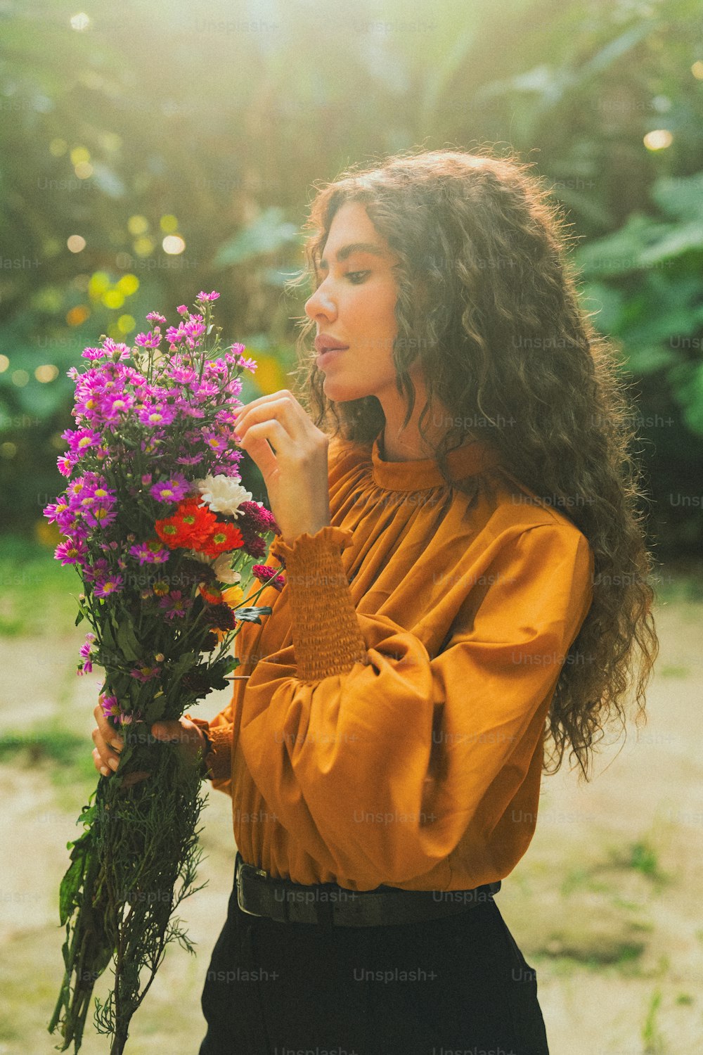 a woman holding a bunch of flowers in her hands