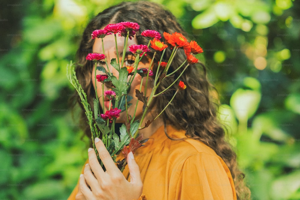 a woman holding a bunch of flowers in front of her face