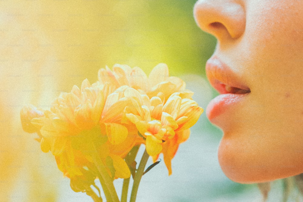 a close up of a person smelling a flower