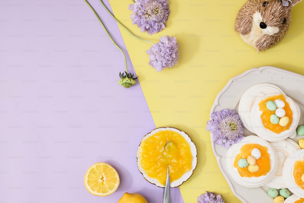 un piatto con cupcakes e un orsacchiotto su sfondo giallo e viola