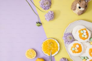 a plate with cupcakes and a teddy bear on a yellow and purple background