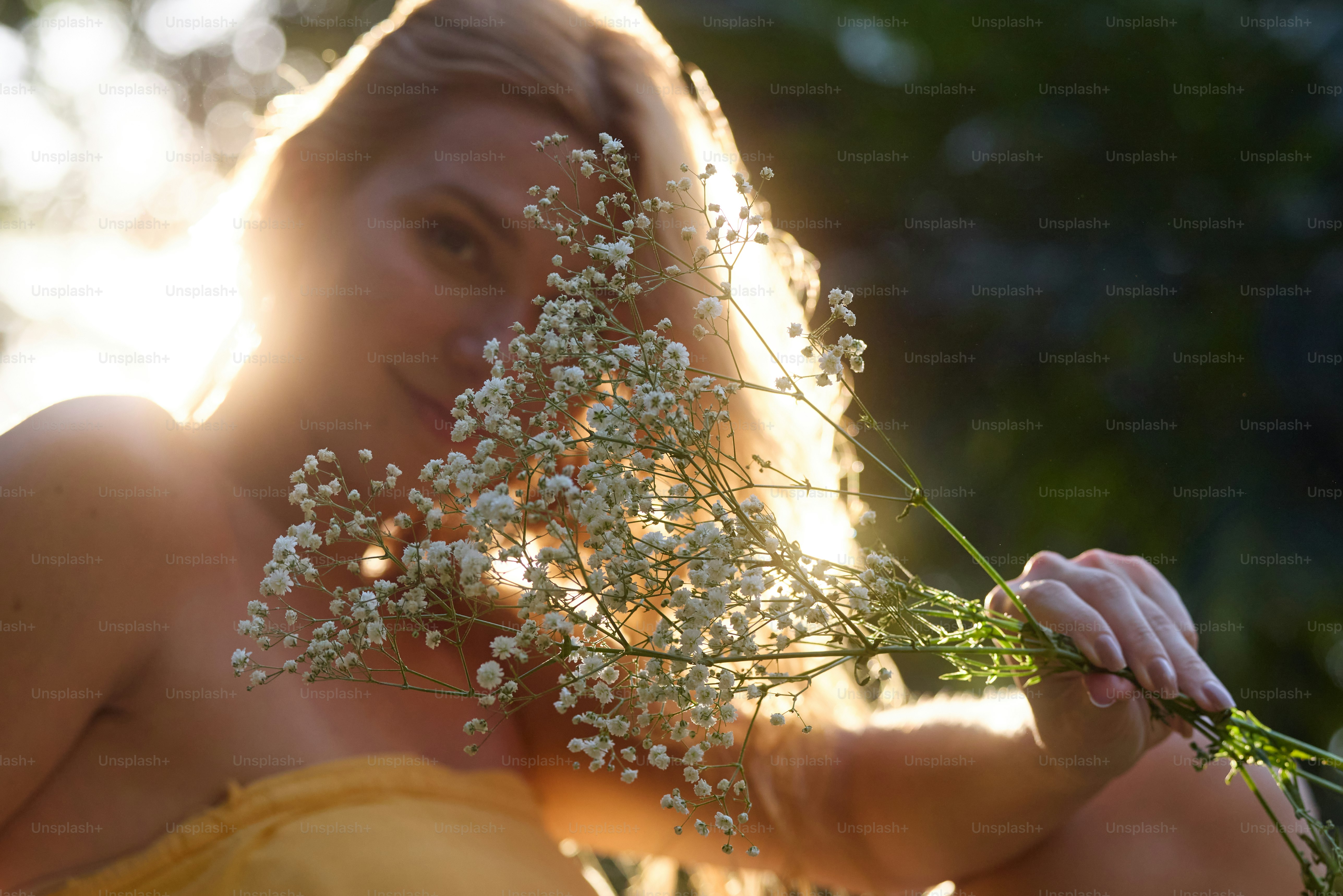 A woman in a yellow dress holding a bunch of flowers photo – Flower ...