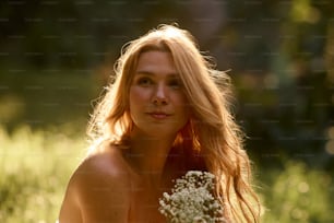una mujer desnuda sosteniendo un ramo de flores