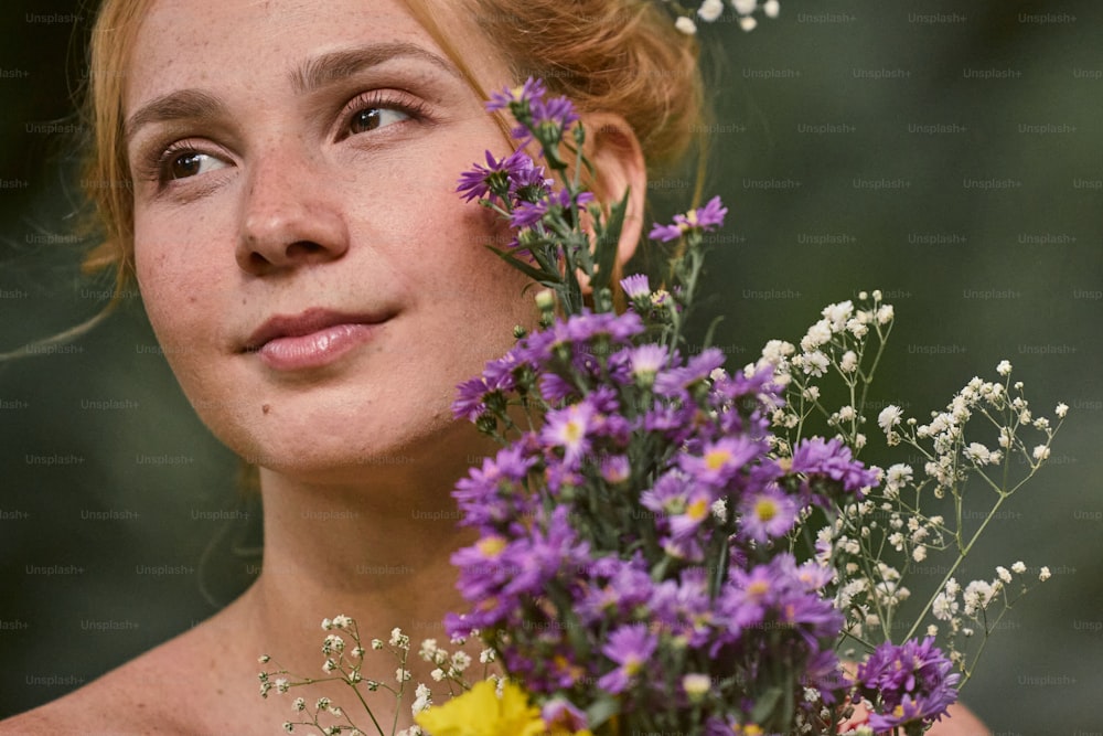 a young woman holding a bouquet of flowers