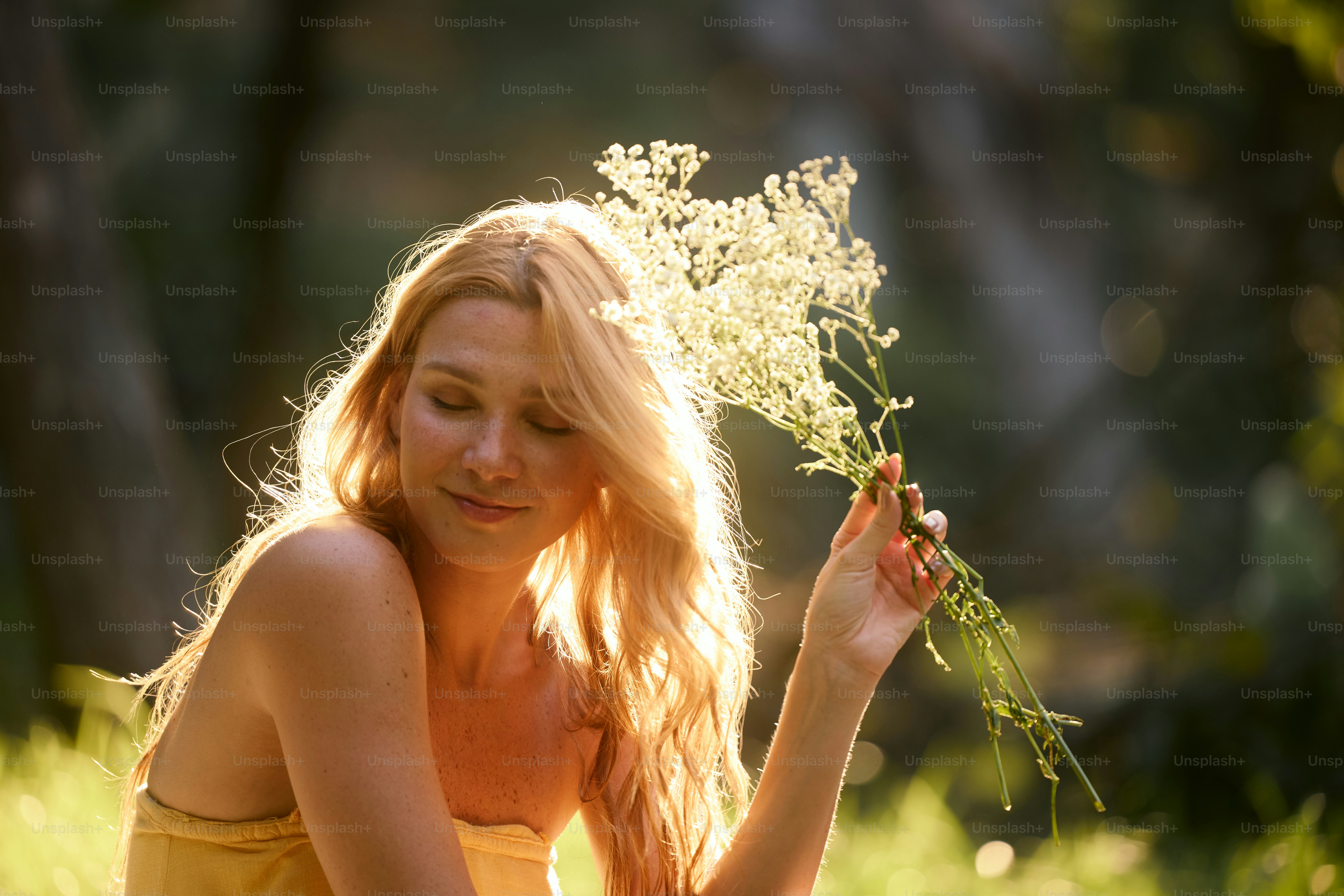 A woman in a yellow dress holding a bunch of flowers photo – Red headed ...