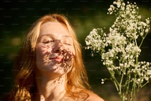 una mujer con los ojos cerrados y un ramo de flores frente a ella
