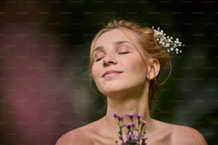 uma mulher de olhos fechados e flores nos cabelos