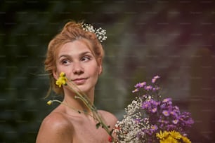 a woman holding a bouquet of wild flowers
