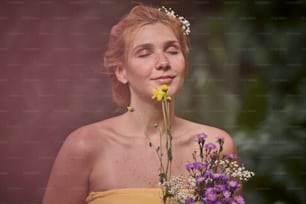 uma mulher em um vestido amarelo segurando um buquê de flores