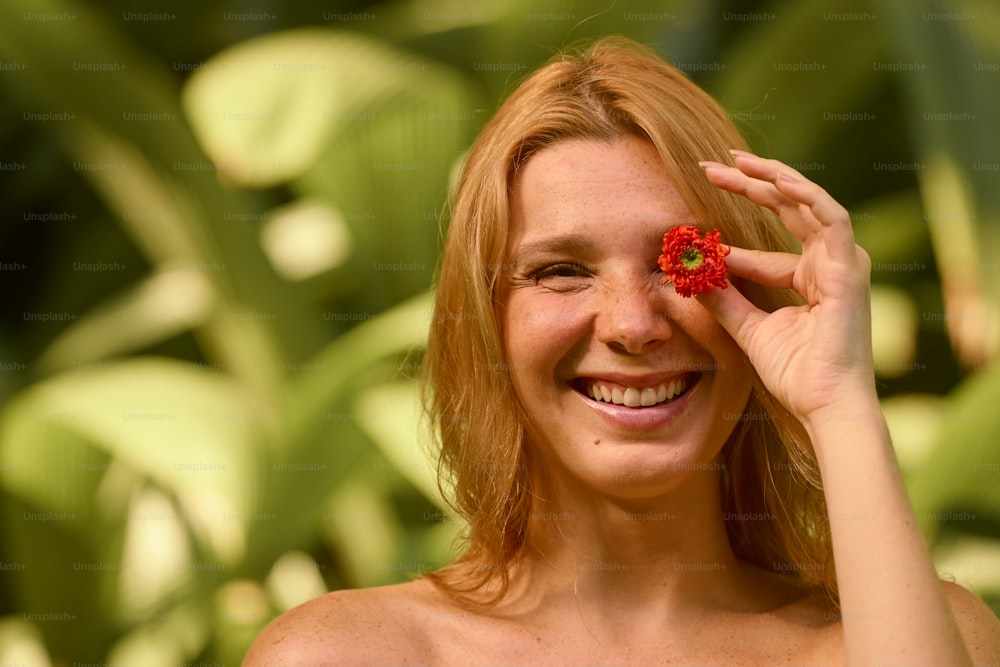 a woman smiling and holding a flower in her hand