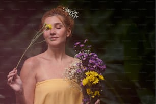 una mujer con un vestido amarillo sosteniendo un ramo de flores