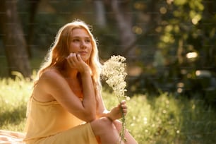 una mujer con un vestido amarillo sosteniendo una flor