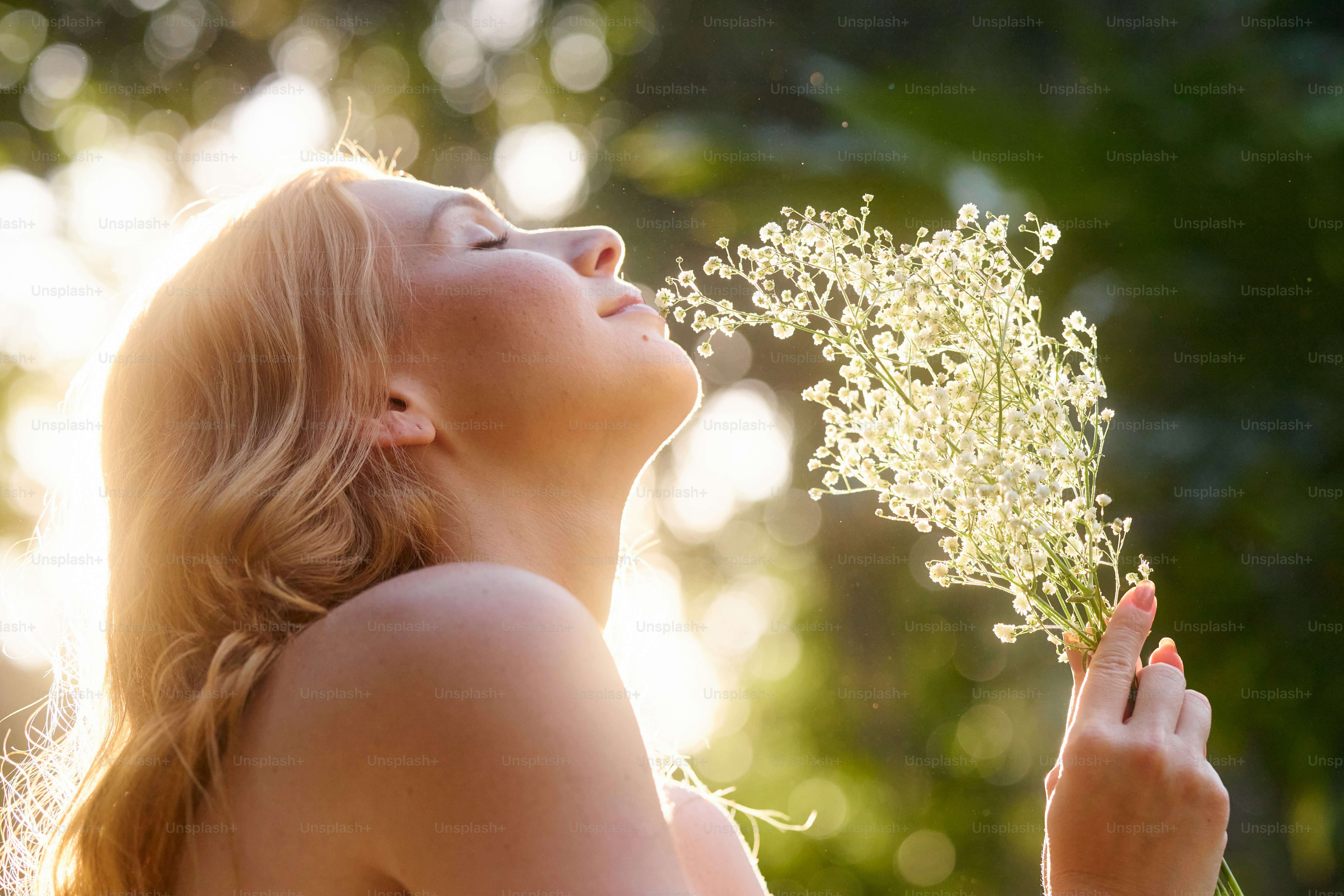 A woman holding a bunch of flowers in her hand photo – Woman Image on ...