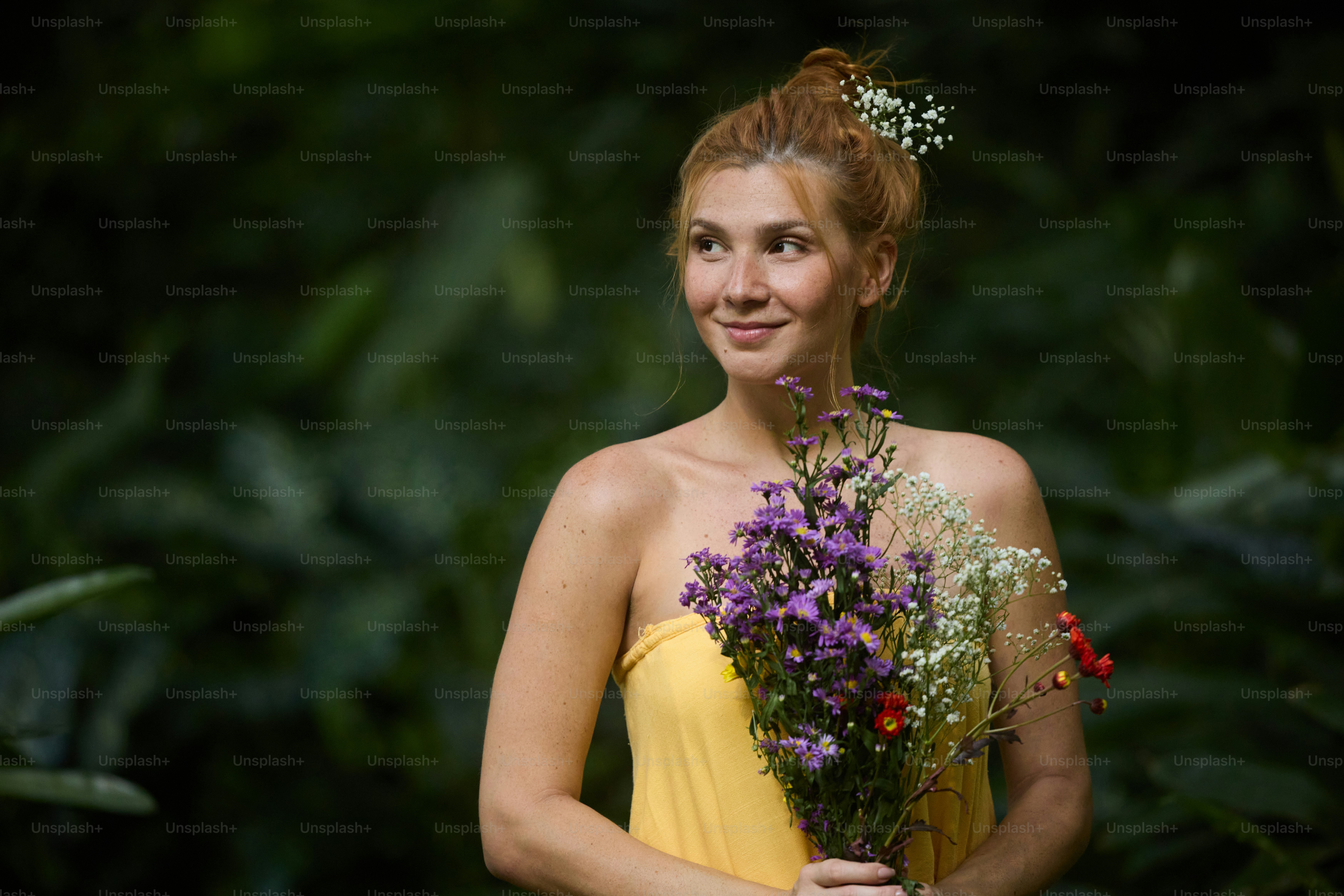 A woman with her eyes closed and a bouquet of flowers in front of her ...