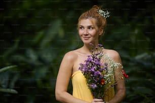 a woman in a yellow dress holding a bouquet of flowers