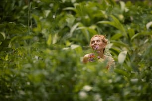 una mujer de pie en medio de un exuberante campo verde