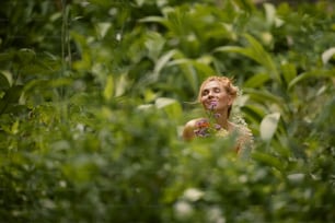 a woman standing in the middle of a lush green field