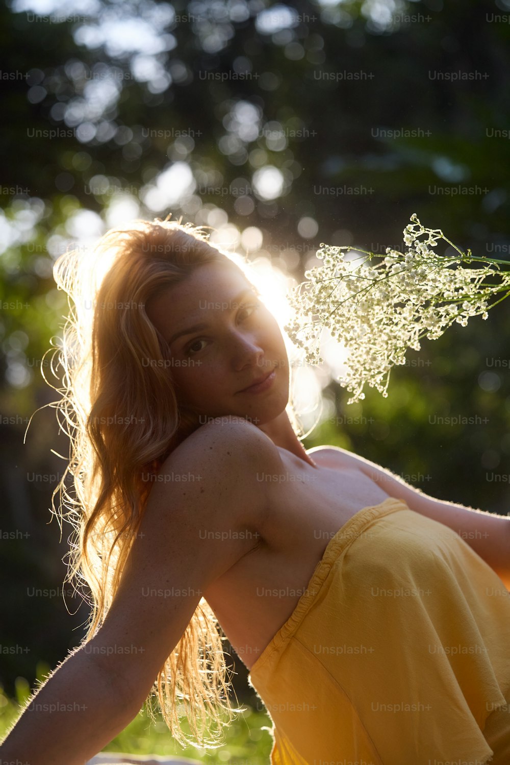 a woman in a yellow dress sitting on a bench