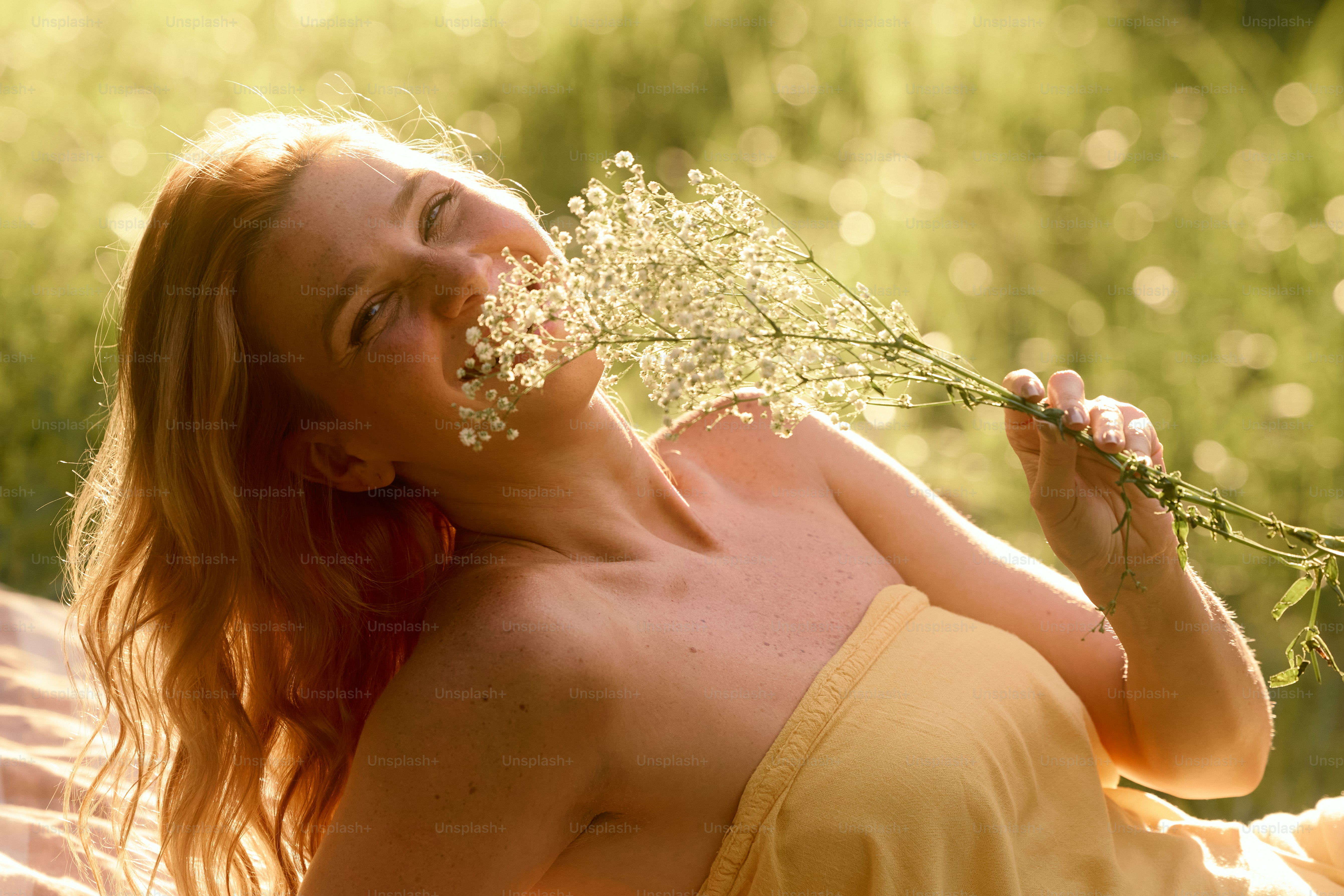 A woman with her eyes closed and a bouquet of flowers in front of her ...