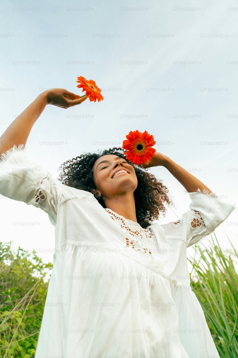 eine Frau in einem weißen Kleid mit einer roten Blume