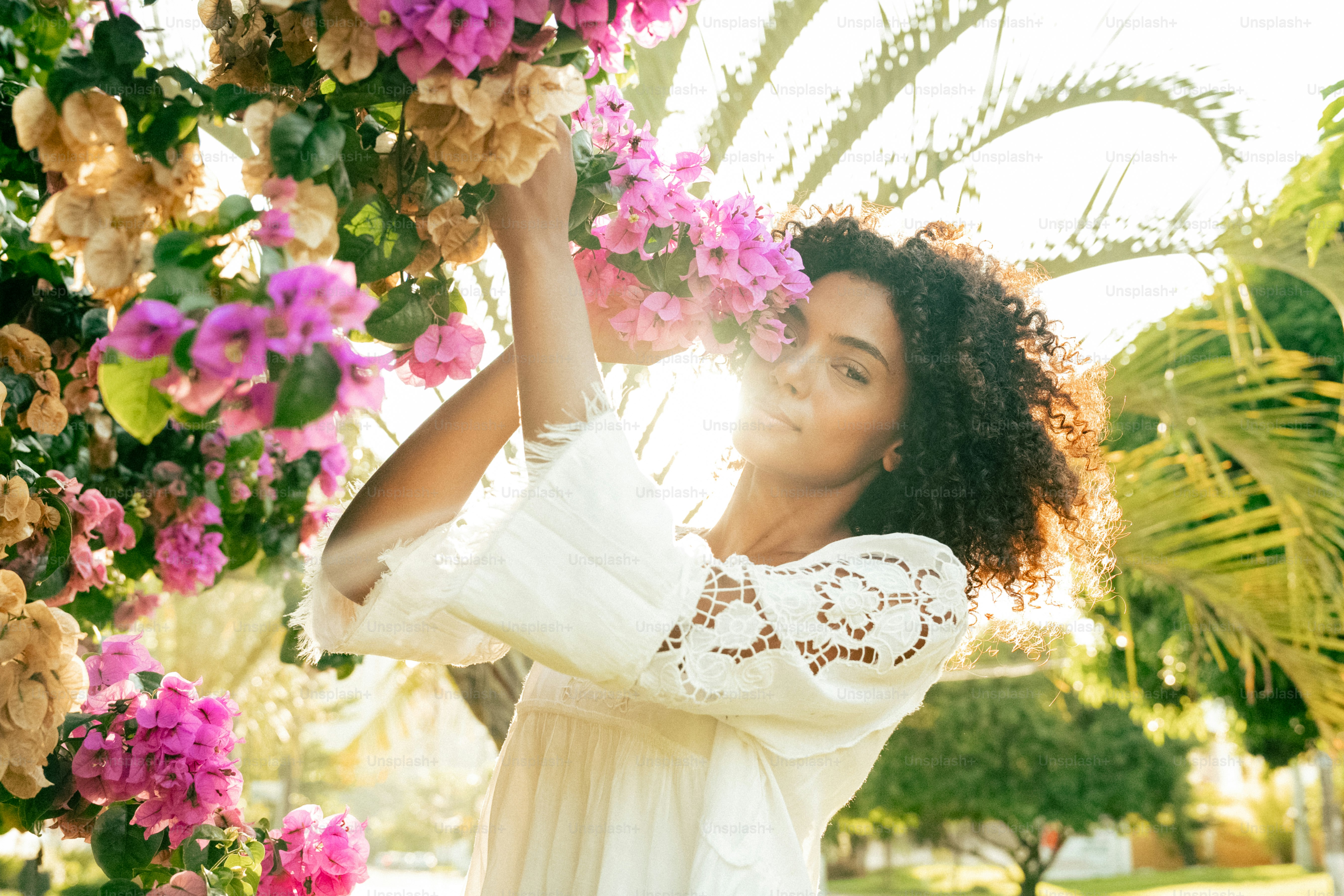 una donna in un vestito bianco che tiene un mazzo di fiori