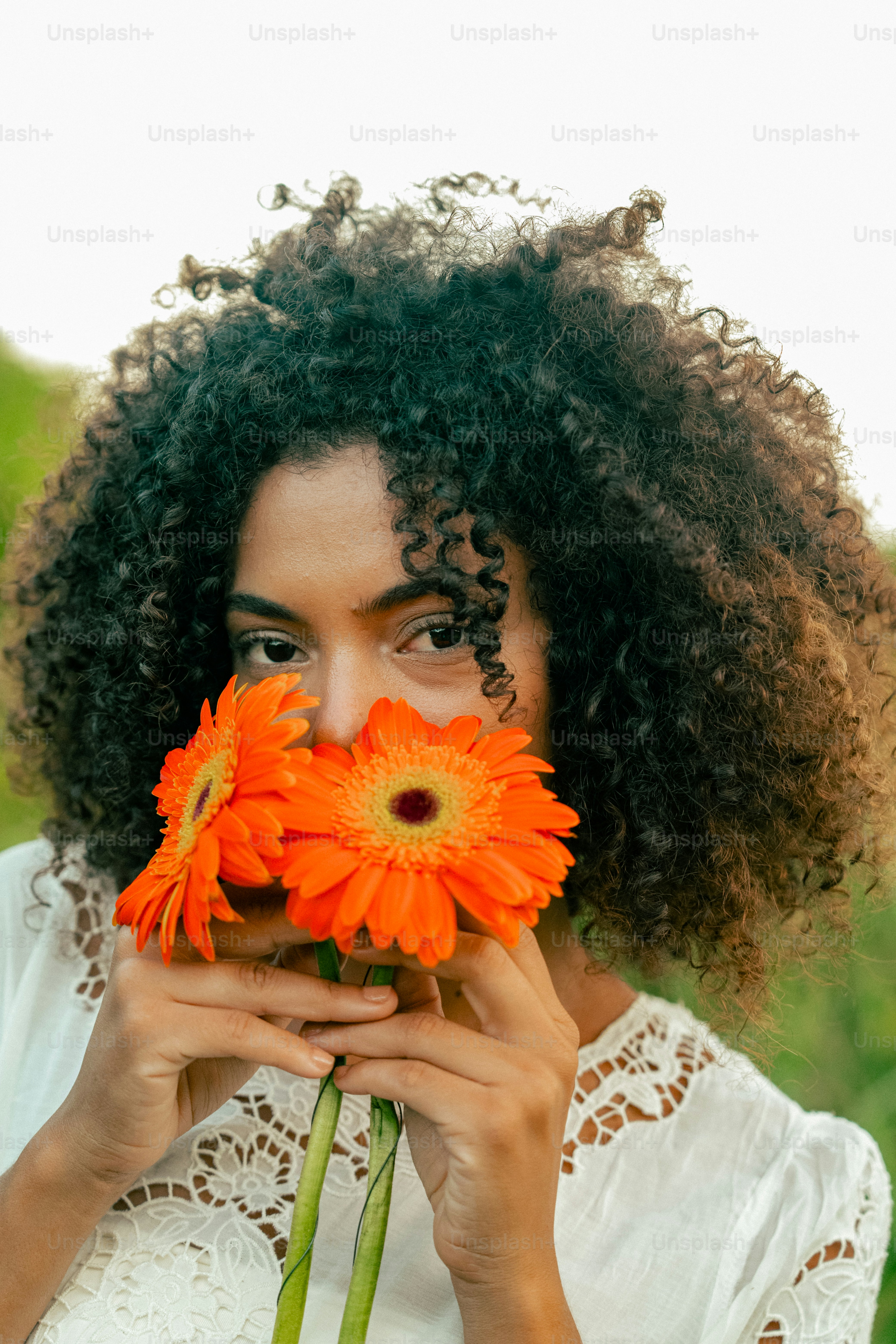 a woman holding a bunch of flowers in front of her face