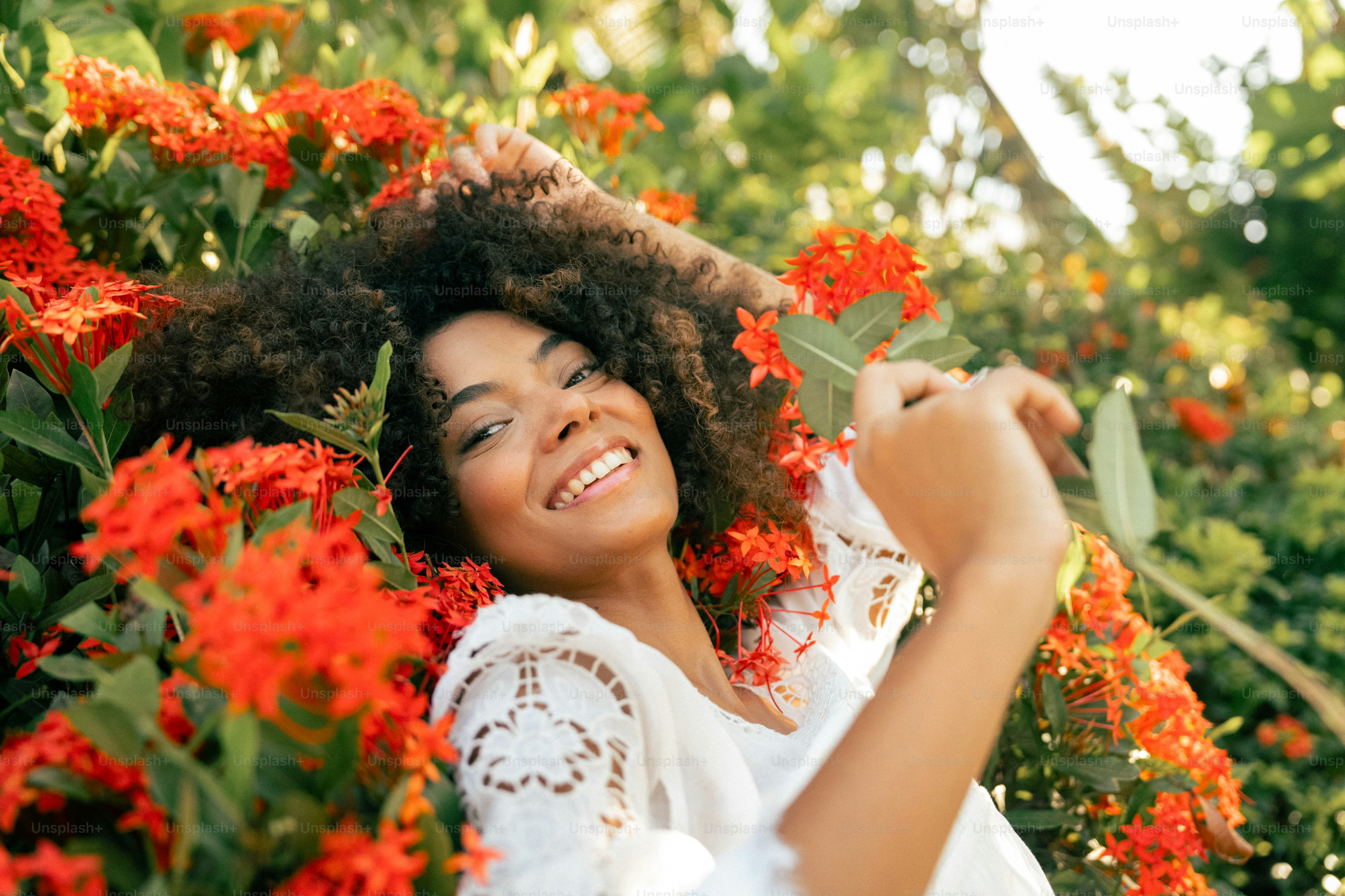 a beautiful woman laying in a field of flowers