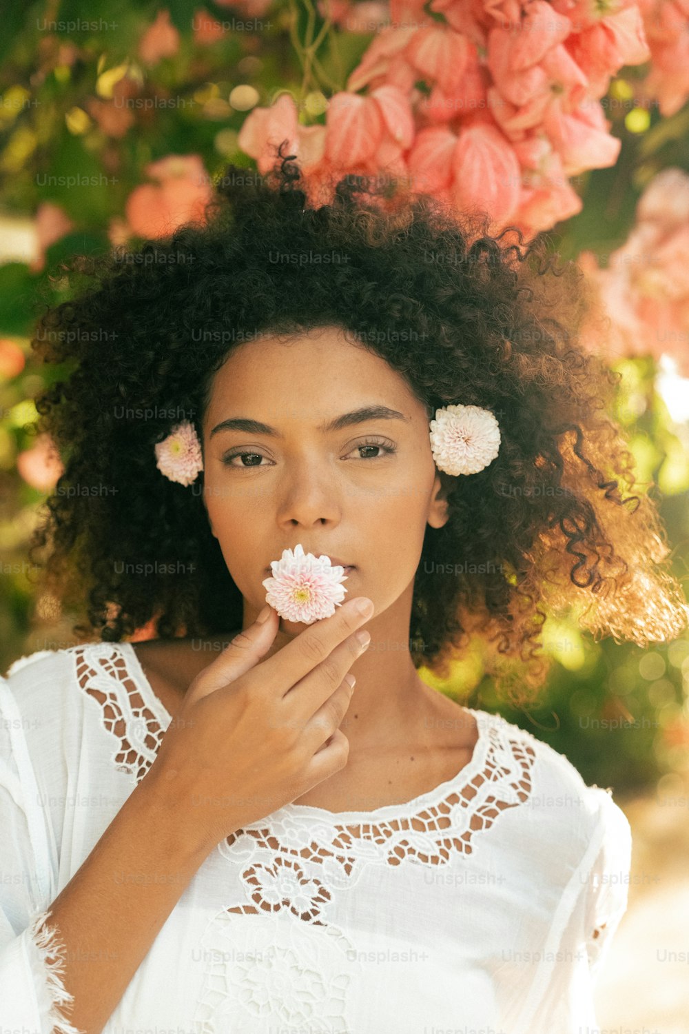 a woman with flowers in her hair blowing her nose