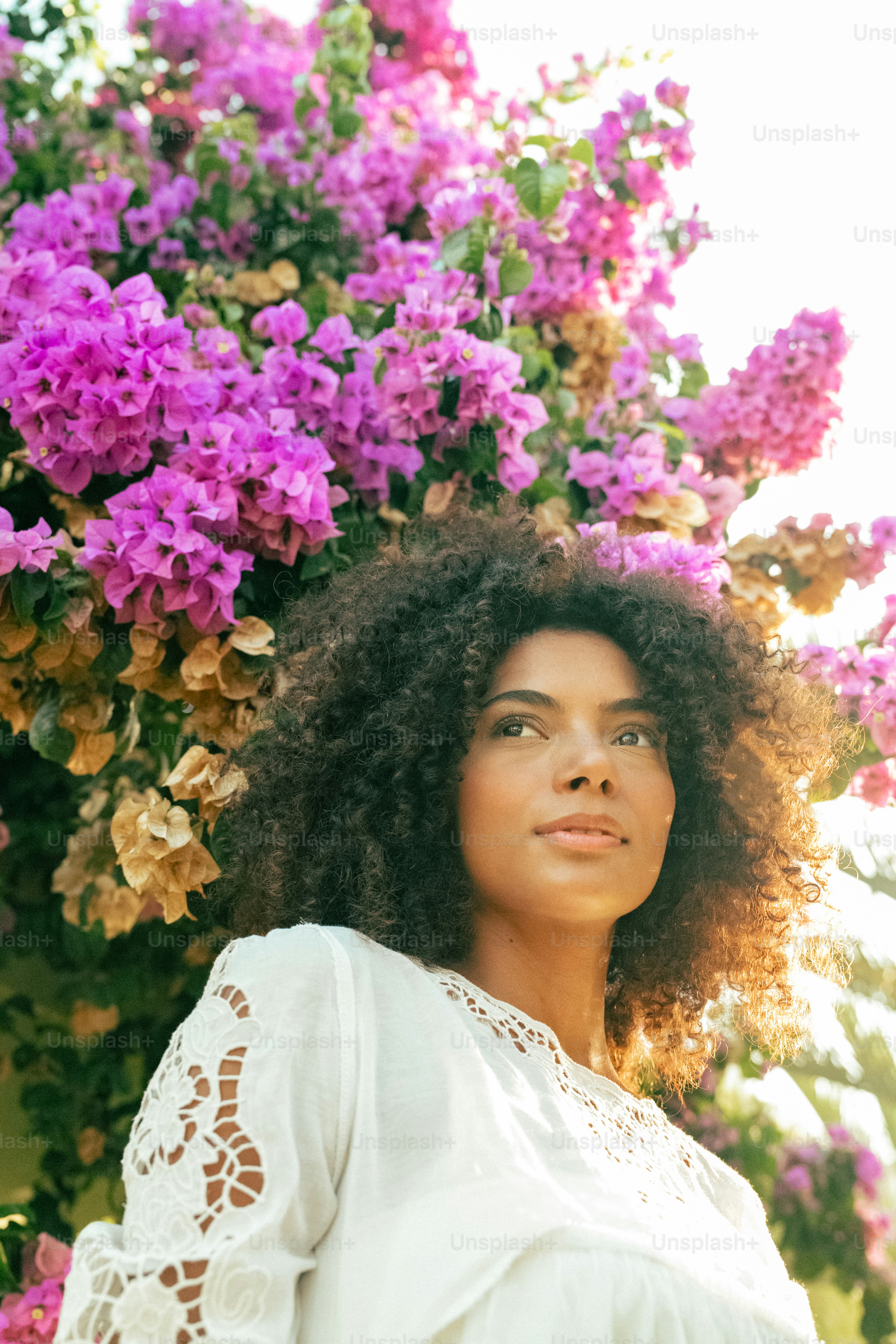 a woman standing in front of a bunch of flowers