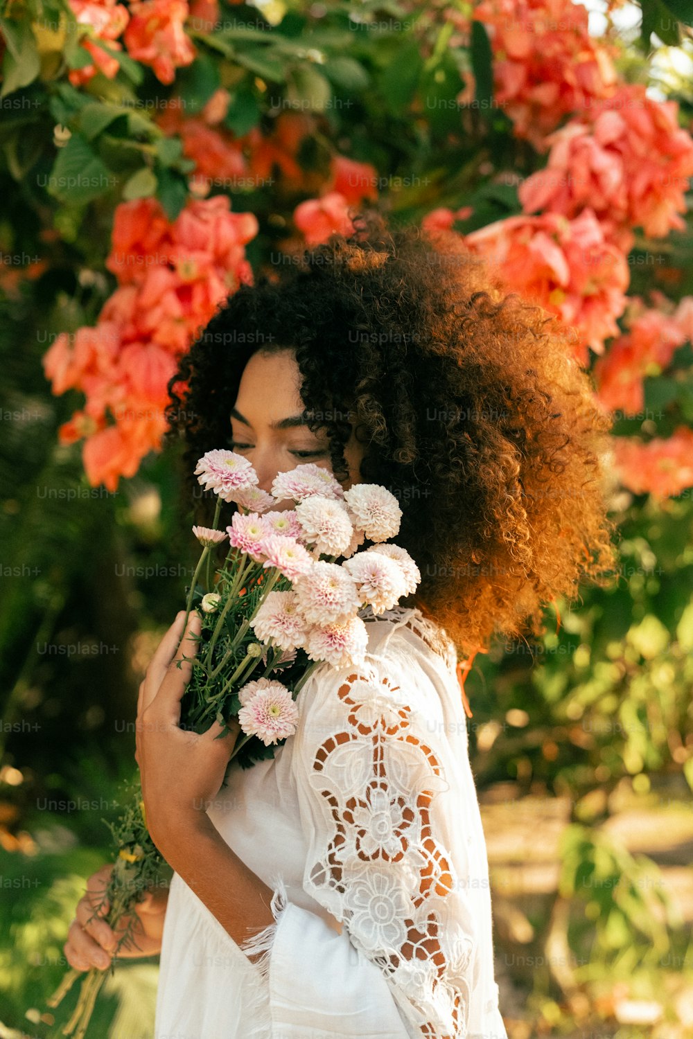 a woman in a white dress holding a bunch of flowers