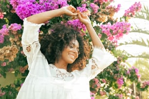 a woman standing in front of purple flowers