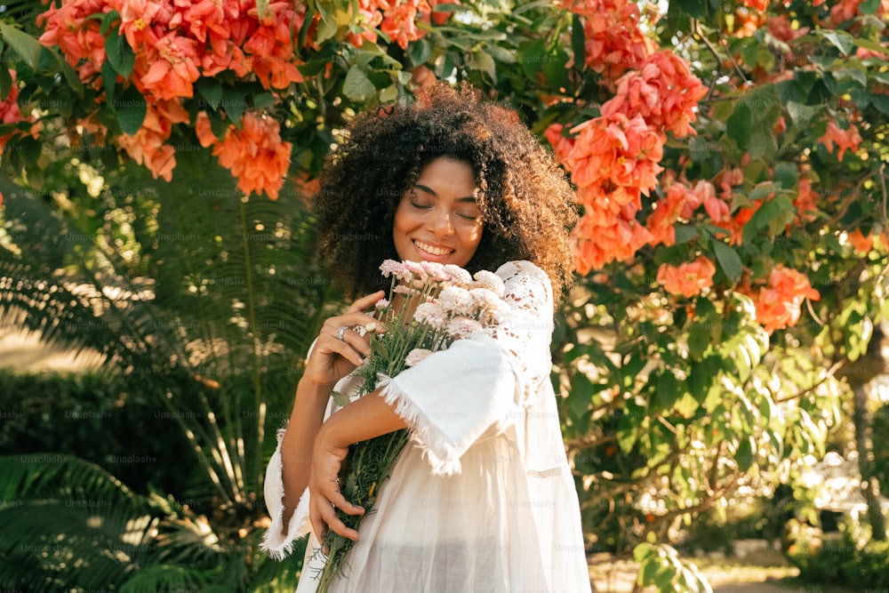 uma mulher em um vestido branco segurando um buquê de flores