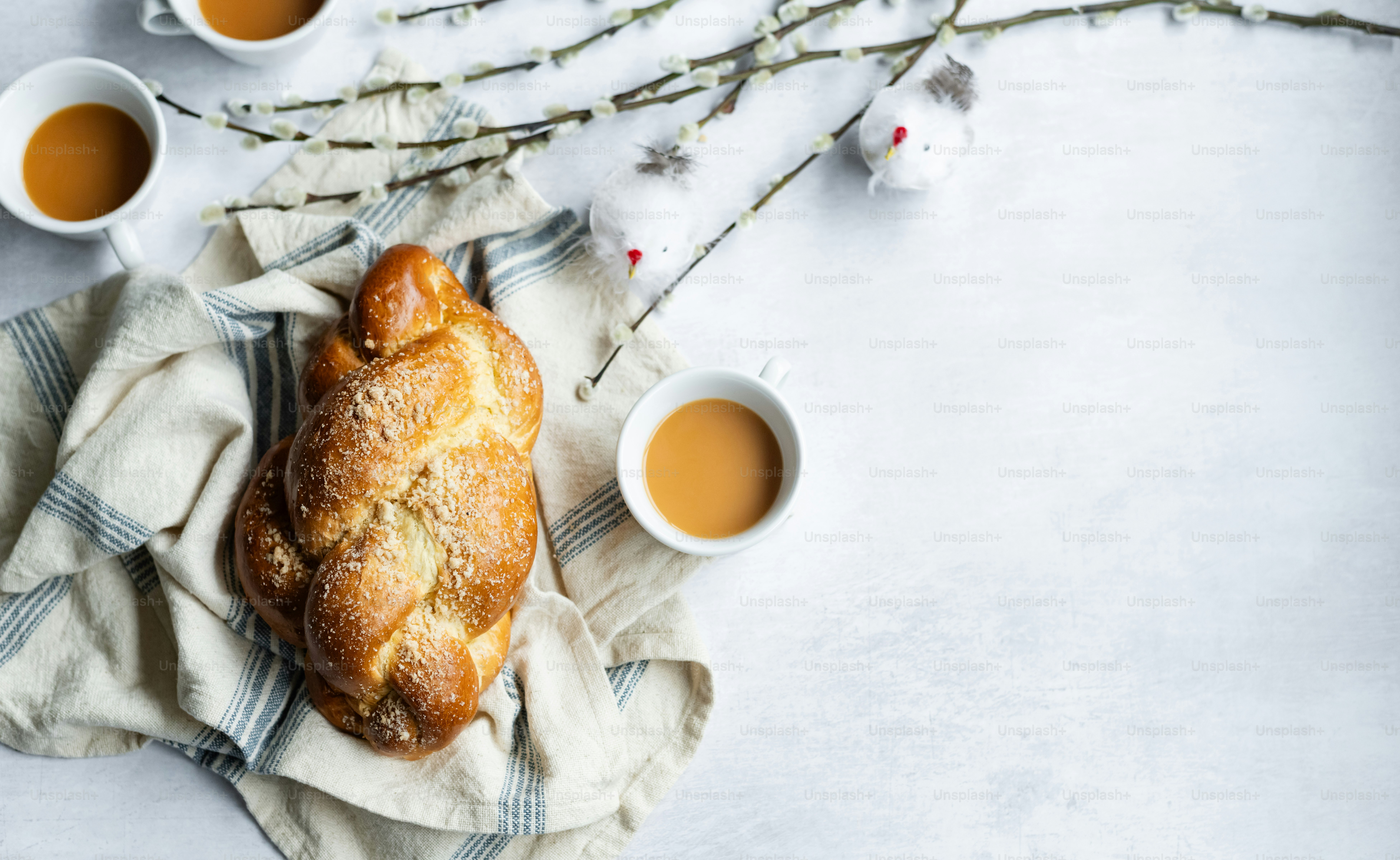 a loaf of bread sitting on top of a cloth next to cups of tea