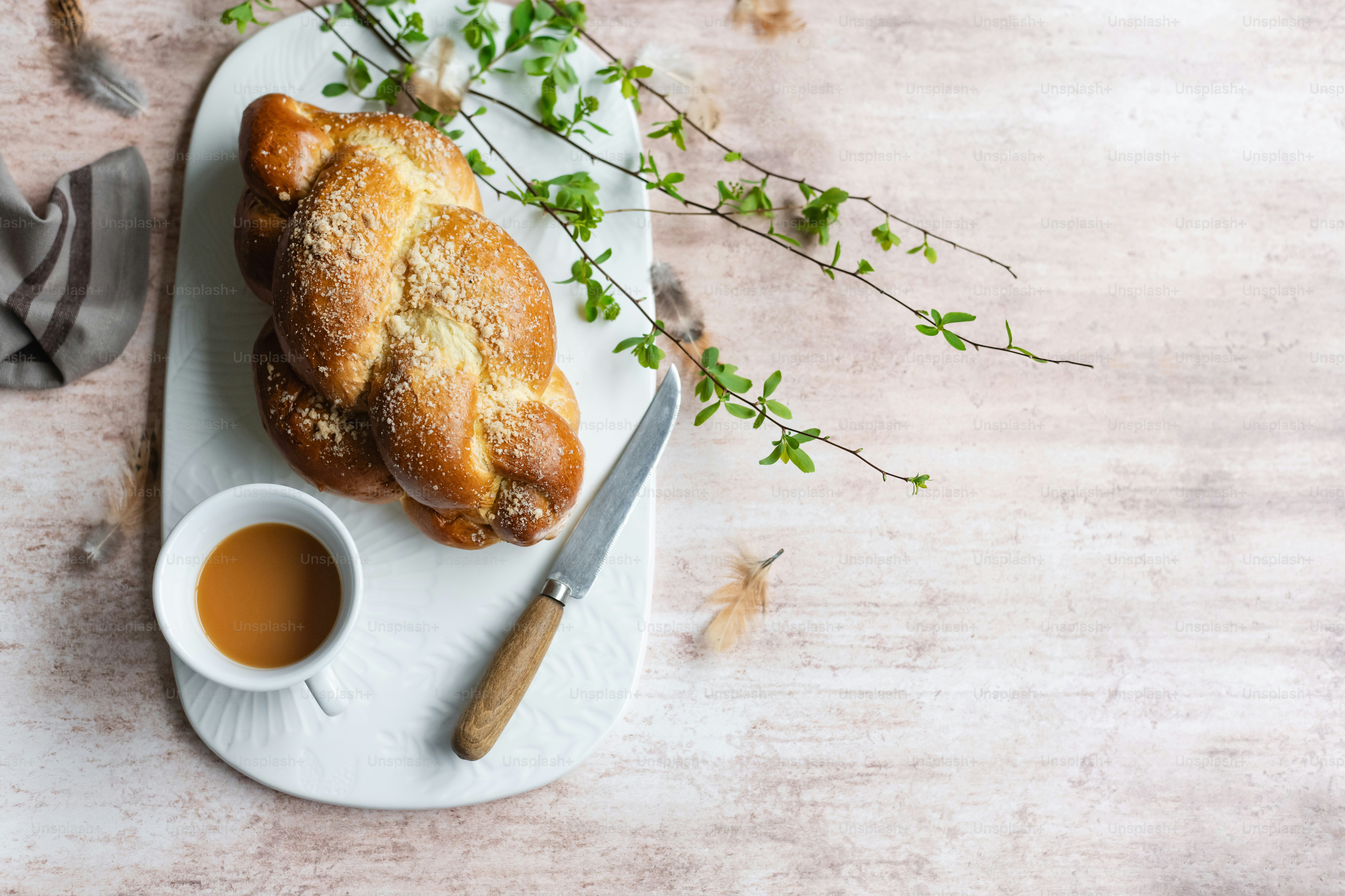 une assiette blanche surmontée d’une pâtisserie à côté d’une tasse de thé